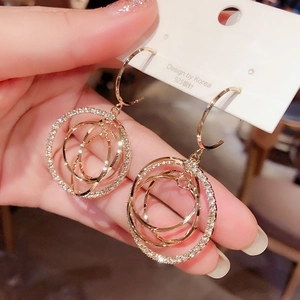 Détail de créoles superposées dorées avec strass et tiges en argent 925
