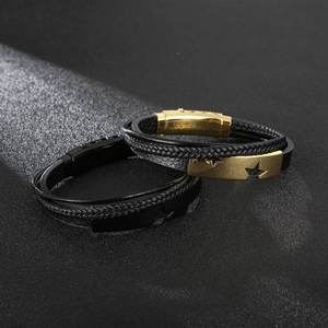 Dettaglio di bracciali in pelle intrecciata con fibbie magnetiche a stella per uomini