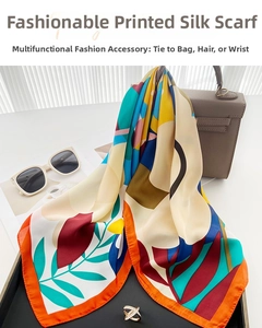 Silk scarf with geometric floral print styled on a brown leather handbag accessory