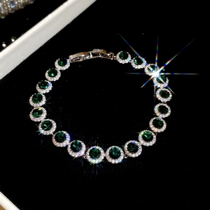 Détail macro d'un bracelet de type tennis avec pierres vert émeraude et pavé de zircons