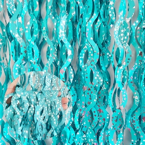 Detail of teal S-shaped spiral fringe curtain with silver star pattern for party decoration