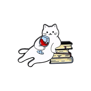 Cute white cartoon cat enamel pin holding a wine glass and leaning on books