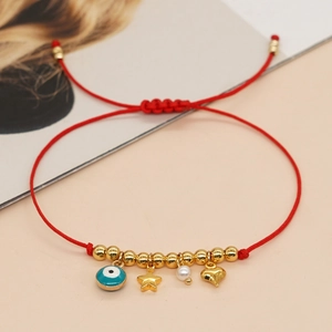 Handmade red braided cord bracelet with gold charms and blue evil eye detail