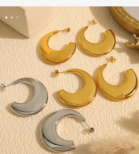 Detail of 18K gold and silver plated C-shape hoop earrings with mirror polished finish