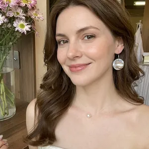 Detailed view of pearl earrings and matching necklace set on female model