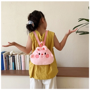 Detail view of the soft pink plush cartoon character backpack worn by a child model