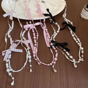 Detail of balletcore handmade pearl necklaces with mesh bows and crystal drop pendants