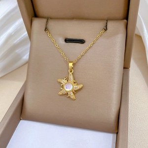 Macro shot of gold starfish necklace with zircon pavé and iridescent center stone