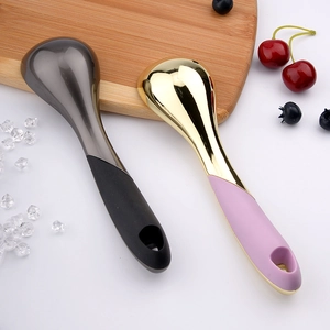 Self-melting ice cream scoops with metal heads and ergonomic handles on a wooden board