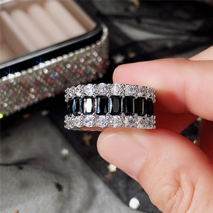 Detail of a wide band ring featuring black rectangular stones and rows of white zircons