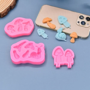 Pink silicone mushroom and snail fondant molds set with orange clay models