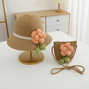 Detailansicht von Strohhut und passender Tasche mit Stoffblume und grünen Blättern