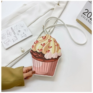 Detail of creative cupcake shaped crossbody bag with heart prints and white leather strap