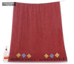 Detail of diamond wine red cotton towel featuring embroidered Nordic Style patterns