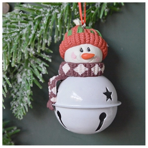 Close-up of snowman Christmas bell with red knit hat and star cutouts on tree branch