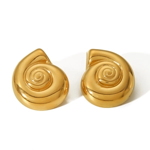 Detailed macro view of spiral conch-shaped gold earrings with polished metallic texture