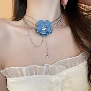 Détail du collier choker fleur en denim avec pendentif zircon et multiples chaînes argentées