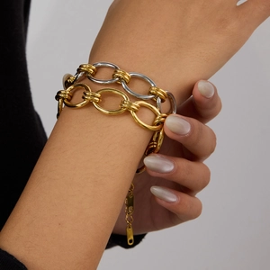 Close-up of gold and silver chunky chain link bracelet worn on a woman wrist