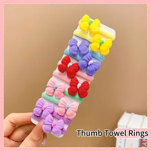 Close-up of 10 colorful elastic thumb towel hair ties with cute plastic bow ornaments