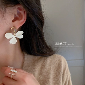 Ensemble élégant de boucles d'oreilles fleurs et bague en T porté par un modèle