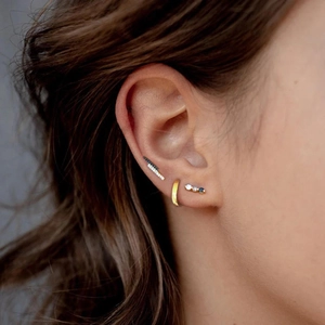 Close-up of gold 925 silver hoop earrings and blue gemstone studs worn on ear