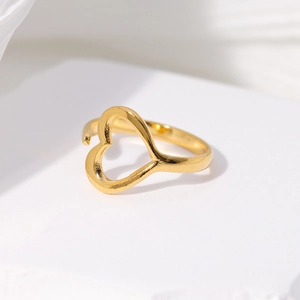 Detail view of a gold hollow heart-shaped open ring on a white display stand
