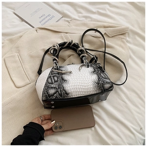 Detail of snake skin pattern faux leather handbag with metal ring handle and strap