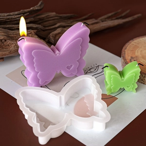 Detail of butterfly silicone mold with lit purple and green handmade candles