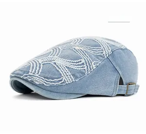 Detail of light blue denim beret showing white stitching and copper metal buckle