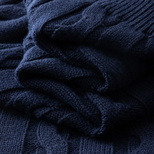 Close-up of navy blue cable knit texture and ribbed pattern on high-quality cotton sweater