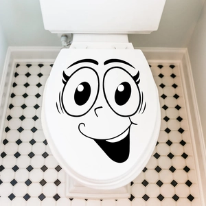 Funny cartoon smile face toilet lid sticker on a white ceramic bathroom seat cover