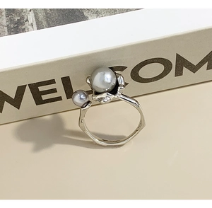 Detail view of irregular S925 sterling silver ring with two grey pearls on magazine