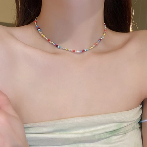 Close-up of colorful seed beads and silver spacer beads choker necklace on a model