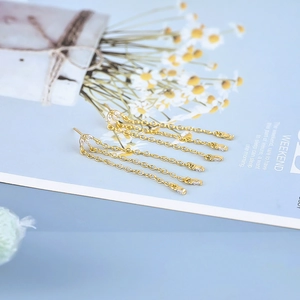 Close-up of luxury gold tassel chain earrings with shimmering white zircon crystals