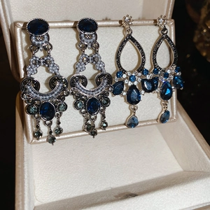 Vintage oval pearl tassel earrings with blue gemstones in a beige jewelry box