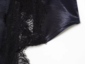 Detailed view of dark blue satin fabric featuring exquisite black lace edge patchwork