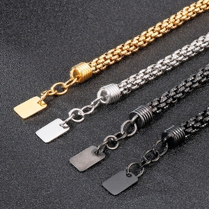 Detail of four woven stainless steel bracelets in gold, silver, dark grey and black