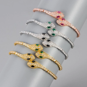 Elegant snake head bangle set with micro-paved diamonds and pear-shaped gemstone eyes