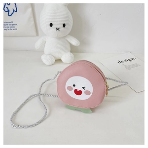 Close-up of pink peach-shaped mini crossbody bag with cute cartoon facial expression