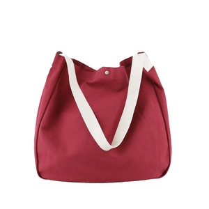 Minimalist canvas tote bag in burgundy with off-white straps for casual daily use