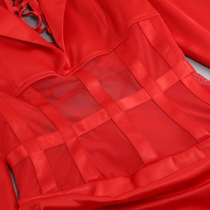 Detail of red satin dress with sheer mesh panels and intricate lace-up cutout design