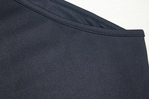 Close-up of double-stitched seams and knit texture on this black sleeveless dress