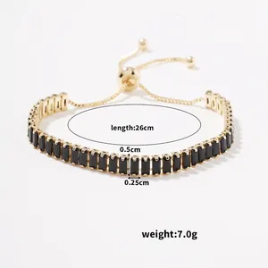 Detail view of gold adjustable bracelet with black rectangular zircons and sliding clasp