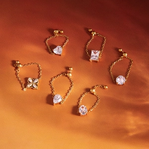 Elegant 6-piece gold-plated earring set with various crystal shapes on an orange background