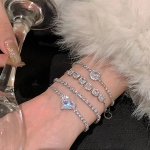Gros plan d'un ensemble de quatre bracelets en strass argentés avec breloques cœurs