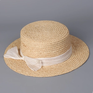 Detailed close-up of woven raffia boater hat texture with delicate silk mesh bow ribbon