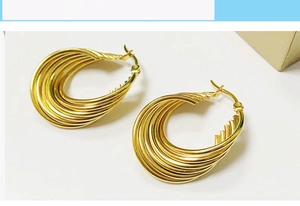 Macro view of gold 18K plated stainless steel multi-layer wave hoop earrings