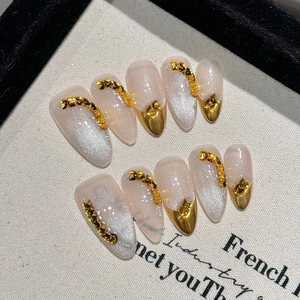 Elegant almond-shaped handmade press-on nails with silver cat-eye and gold chain accents