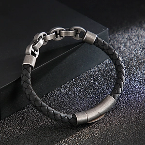 Close-up of woven leather men's bracelet with antique silver chain link and magnetic clasp