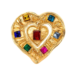 Vintage gold heart brooch with colorful crystals and hanging red gem on white background